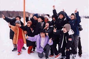 アンカレッジ市の凍ったフッド湖にて，飯干小学校全校生徒13人と一緒に